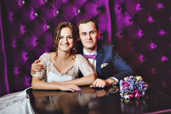 Bröllopsdag. Bruden och brudgummen i lyxig inredning i lavendel färg. Bröllop känslor. Vackra brudparet eleganta vid ceremonin. — Stockfoto