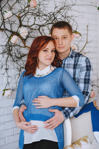 Těhotná mladý pár v lásce, stojící poblíž. Manžel obejme svou ženu. S barvami z růženínu a nebeská modř. — Stock fotografie