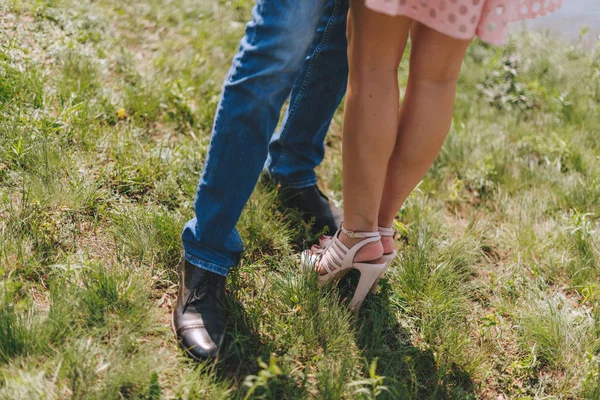 Feet legs couple in love. Walking on green grass.