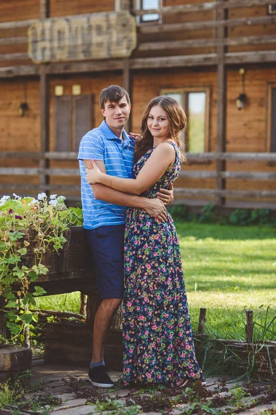 Romantic young couple hugging each other on the background of the hotel in a rustic style. — Stock Photo, Image