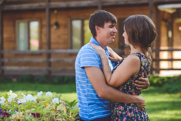 Pasangan muda yang romantis berpelukan satu sama lain di latar belakang hotel dengan gaya pedesaan . — Stok Foto