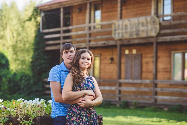 Pasangan muda yang romantis berpelukan satu sama lain di latar belakang hotel dengan gaya pedesaan . — Stok Foto
