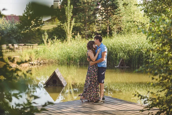 Boldog romantikus pár fahíd a tónál. Az ember magába foglal egy fiatal nő. — Stock Fotó