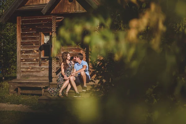 Pár férfiak és a nők, a falu, a fából készült ház közelében. Vidéki stílusban. Rusztikus nyári. — Stock Fotó
