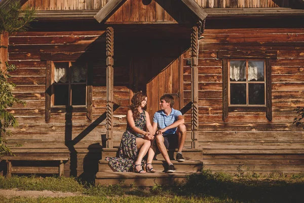 Пара чоловіків і жінок в селі, біля дерев'яного будинку . — стокове фото