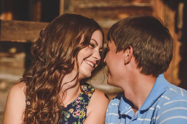 Un par de hombres y mujeres en el pueblo, cerca de una casa de madera. Rostros cerca el uno del otro. Concepto: amor, romance, verano . — Foto de Stock