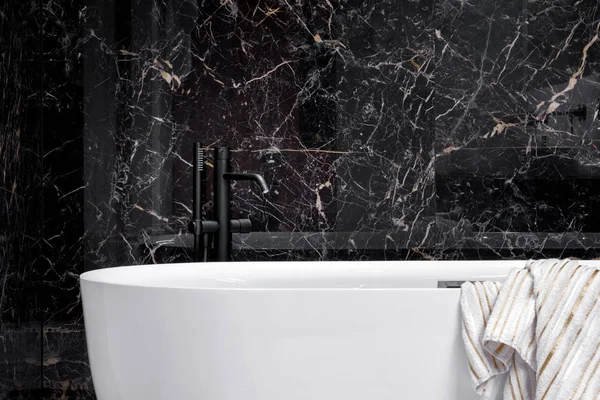 Svart kran i elegant vitt badkar — Stockfoto