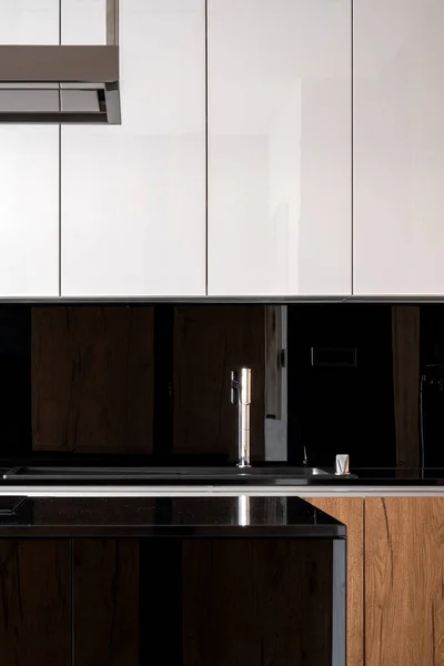 精致的厨房 有黑色的背面水花 黑色的厨房岛和白色的橱柜 — 图库照片