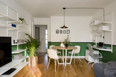 Küçük ve şık tasarlanmış bir daire. Oturma odası, yemek odası ve ev ofisi aynı odada.
