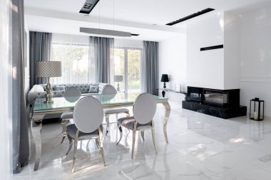 Beyaz, gümüş, koyu mermer şömine ve beyaz mermer döşemeli göz kamaştırıcı oturma odası.