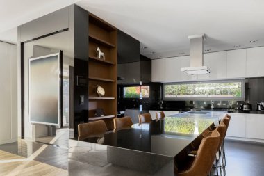 Siyah-beyaz zarif ve ferah mutfak, yemek alanı sekiz kişilik.