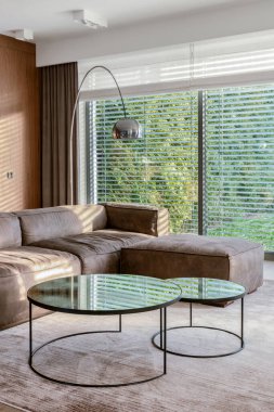 Şık kahve masaları ve oturma odasında büyük pencereli zarif bir kanepe.