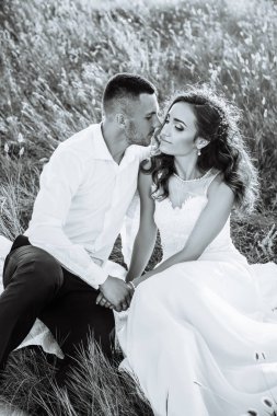 Güzel çift alanına, aşık veya mükemmel gökyüzü günbatımı poz yeni evli. Siyah ve beyaz