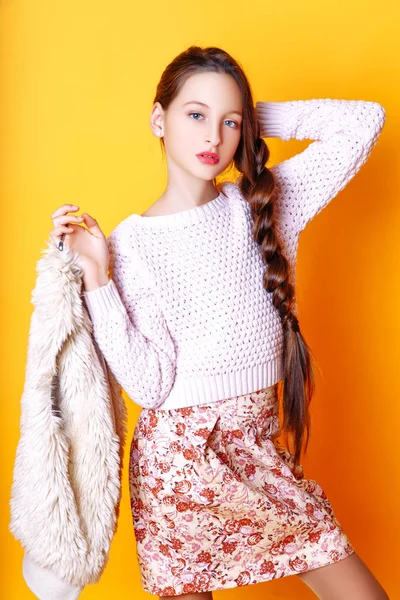 Linda menina da moda bonito adolescente em uma camisola e um skir no fundo amarelo com cabelo longo posando — Fotografia de Stock