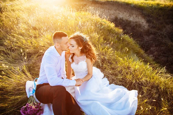 Красива пара в полі, коханці або новоспечені позують на заході сонця з ідеальним небом — стокове фото