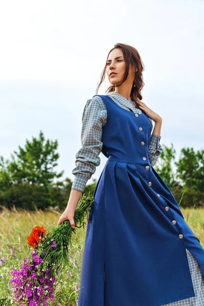Zewnątrz portret pięknej kobiety brunetka w niebieską sukienkę w polu — Zdjęcie stockowe