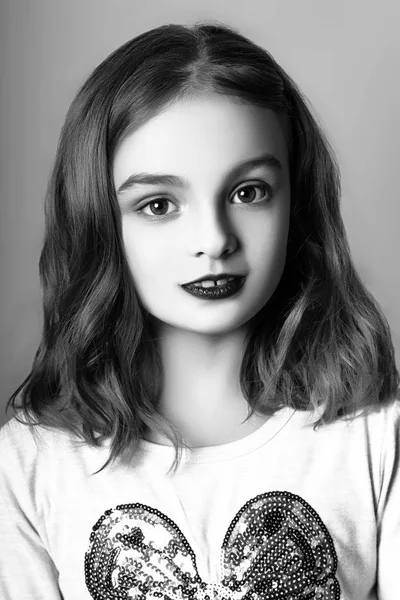 Jolie petite fille aux lèvres rouges posant en studio. Noir et blanc — Photo