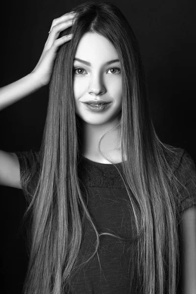 Linda chica adolescente con el pelo largo posando retrato de la naturaleza del estudio. Blanco y negro —  Fotos de Stock