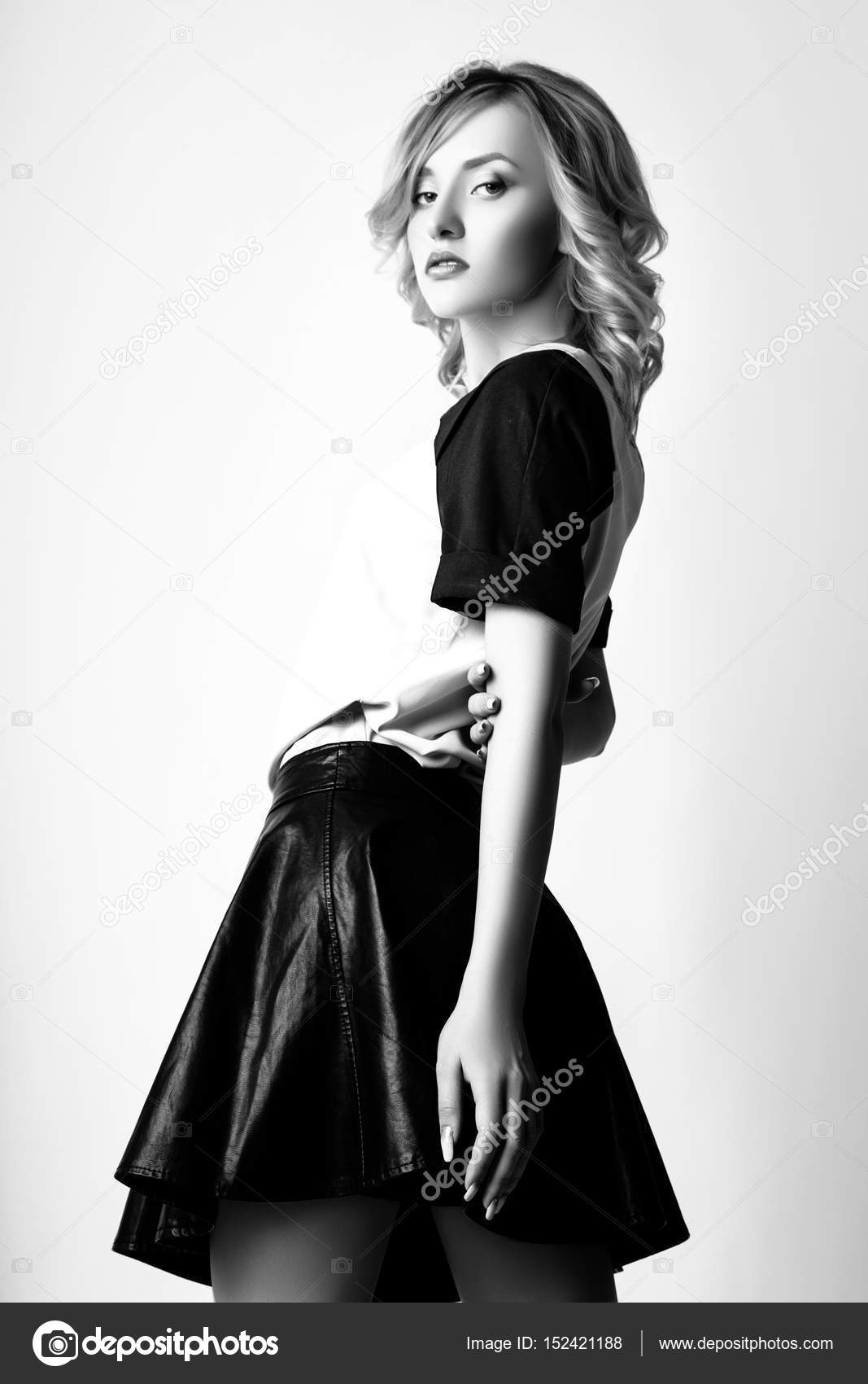 Studio photo of young curly blonde woman on white background