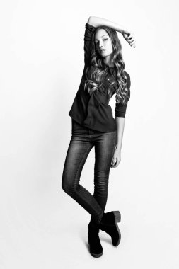 Moda portre sarışın saçlı güzel genç kadın. Kız mavi bir gömlek ve beyaz bir arka plan üzerinde kot pantolon. Siyah ve beyaz