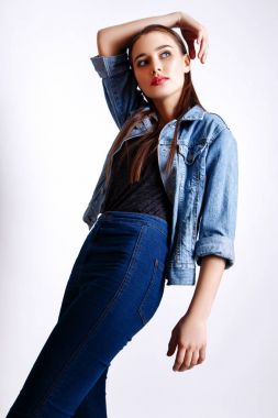 Güzel kadın sihir modeli moda giysiler giymek, rahat tarzı. Oldukça koyu saçlı beyaz arka plan stüdyo yüz.