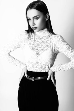 Güzel kadın sihir modeli moda giysiler giymek, rahat tarzı. Oldukça koyu saçlı beyaz arka plan stüdyo yüz. Siyah ve beyaz