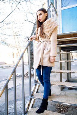 Bej bir palto, genç güzel kadın portresi sonbahar açık havada