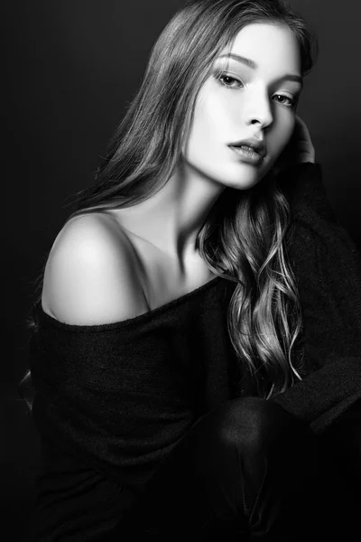 Fashion portrait of beautiful young woman with blond hair. Girl in a a blue pullover on a black background. Black and white — Stock Photo, Image