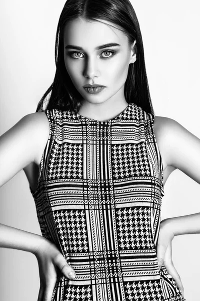 Güzel kadın sihir modeli moda giysiler giymek, rahat tarzı. Oldukça koyu saçlı beyaz arka plan stüdyo yüz. Siyah ve beyaz