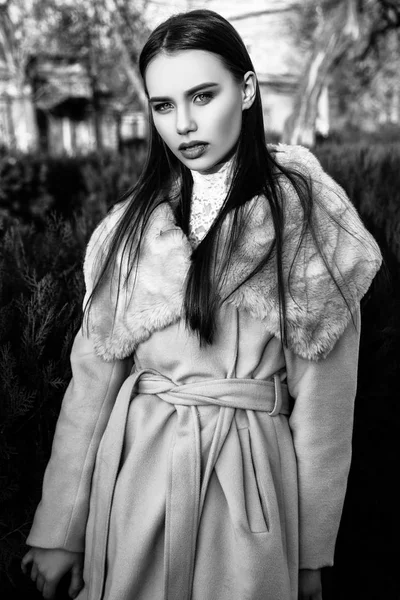Porträt einer jungen schönen Frau im beigen Mantel, Herbst im Freien. schwarz-weiß — Stockfoto