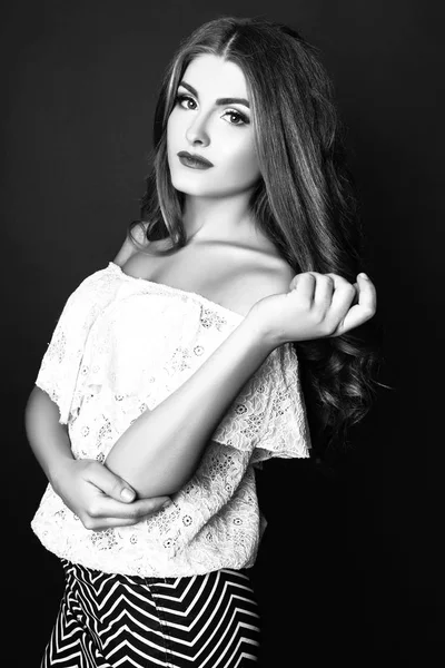 Fashion portrait of beautiful young woman with long hair. Girl in a white blouse and skirt on a black background. Black and white — Stock Photo, Image
