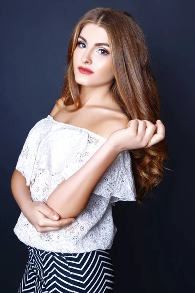 Fashion portrait of beautiful young woman with long hair. Girl in a white blouse and skirt on a black background — Stock Photo, Image
