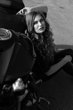 Bir motosiklet ile bir güzel motorcu kızın siyah ve beyaz fotoğraf