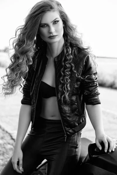 Bir motosiklet ile bir güzel motorcu kızın siyah ve beyaz fotoğraf