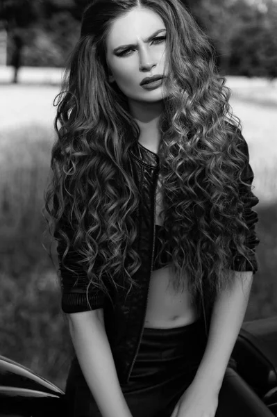 Black and white photo of a beautiful biker girl with a motorcycle — Stock Photo, Image