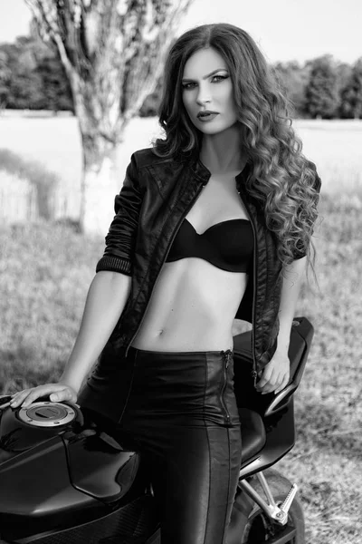Bir motosiklet ile bir güzel motorcu kızın siyah ve beyaz fotoğraf