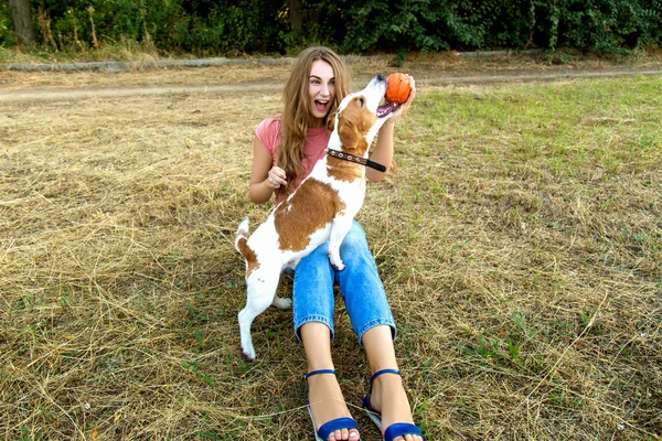 Nettes Mädchen spielt mit ihrem Hund im Park — Stockfoto