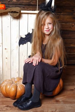 bir cadı bir kabak üzerinde oturur gibi küçük bir kız kılığında. Cadılar Bayramı kavramı