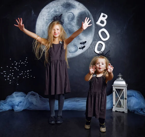 İki sevimli küçük kız kardeş cadı kostümler giymiş