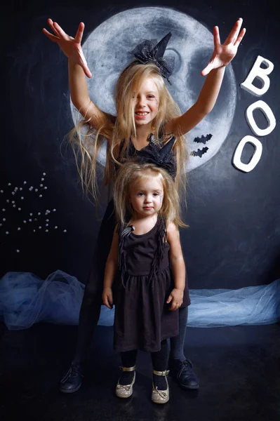 Dos monas hermanas están vestidas con disfraces de brujas — Foto de Stock