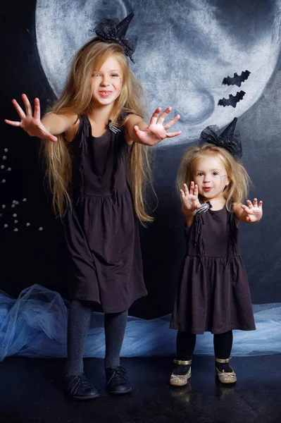 İki sevimli küçük kız kardeş cadı kostümler giymiş