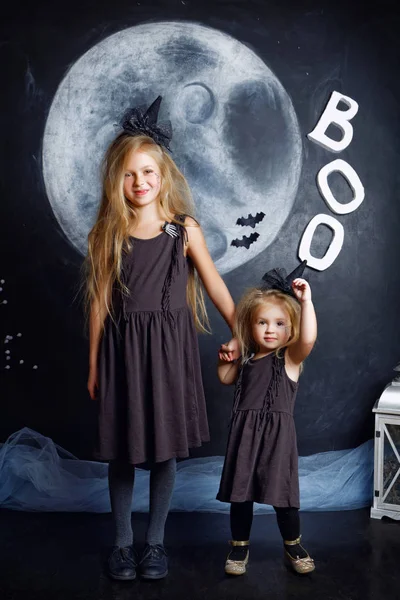 İki sevimli küçük kız kardeş cadı kostümler giymiş