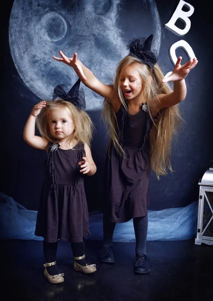 İki sevimli küçük kız kardeş cadı kostümler giymiş