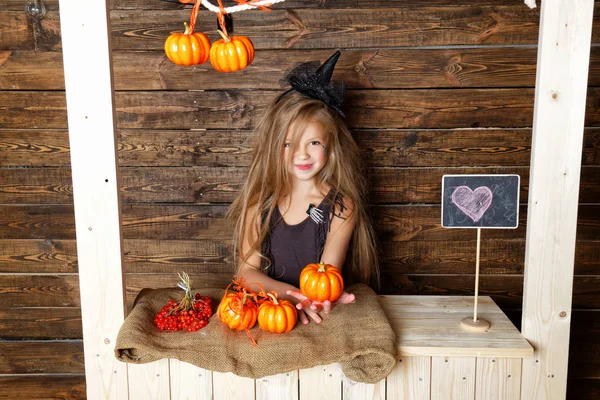 küçük kız bir cadı gibi giyinmiş kabaklar satıyor