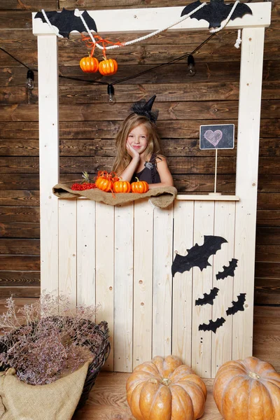 küçük kız bir cadı gibi giyinmiş kabaklar satıyor