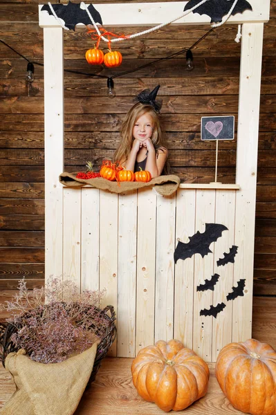 küçük kız bir cadı gibi giyinmiş kabaklar satıyor