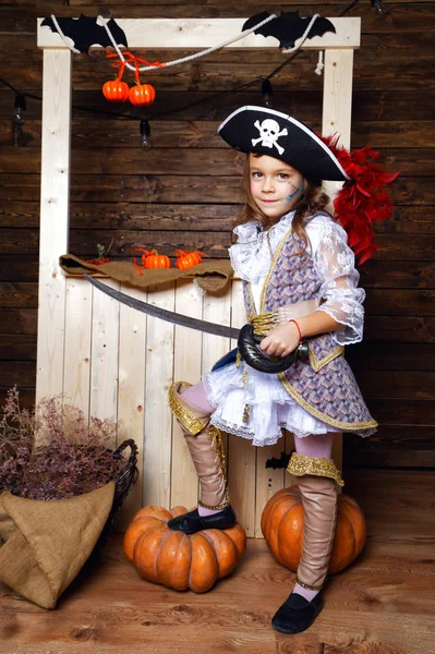 Смішна дівчина в піратському костюмі в студії з пейзажами на Хеллоуїн — стокове фото