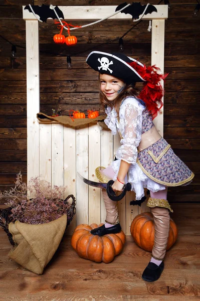 Chica divertida en traje de pirata en el estudio con paisajes para Halloween — Foto de Stock