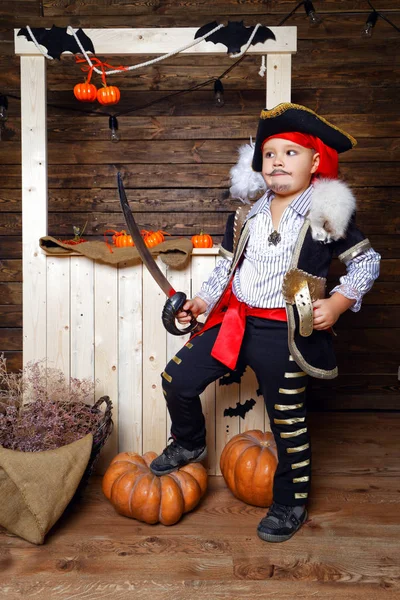 Смішний хлопчик в піратському костюмі в студії з пейзажами на Хеллоуїн — стокове фото
