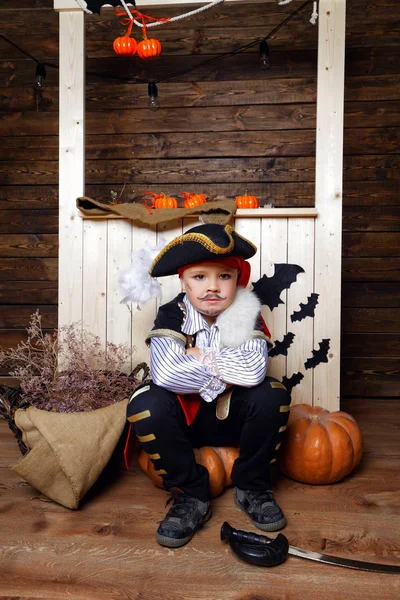 Смішний хлопчик в піратському костюмі в студії з пейзажами на Хеллоуїн — стокове фото